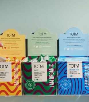 Support periods in the workplace with a free product provision. Image shows hand reaching for a tampon in one of TOTM's workplace boxes